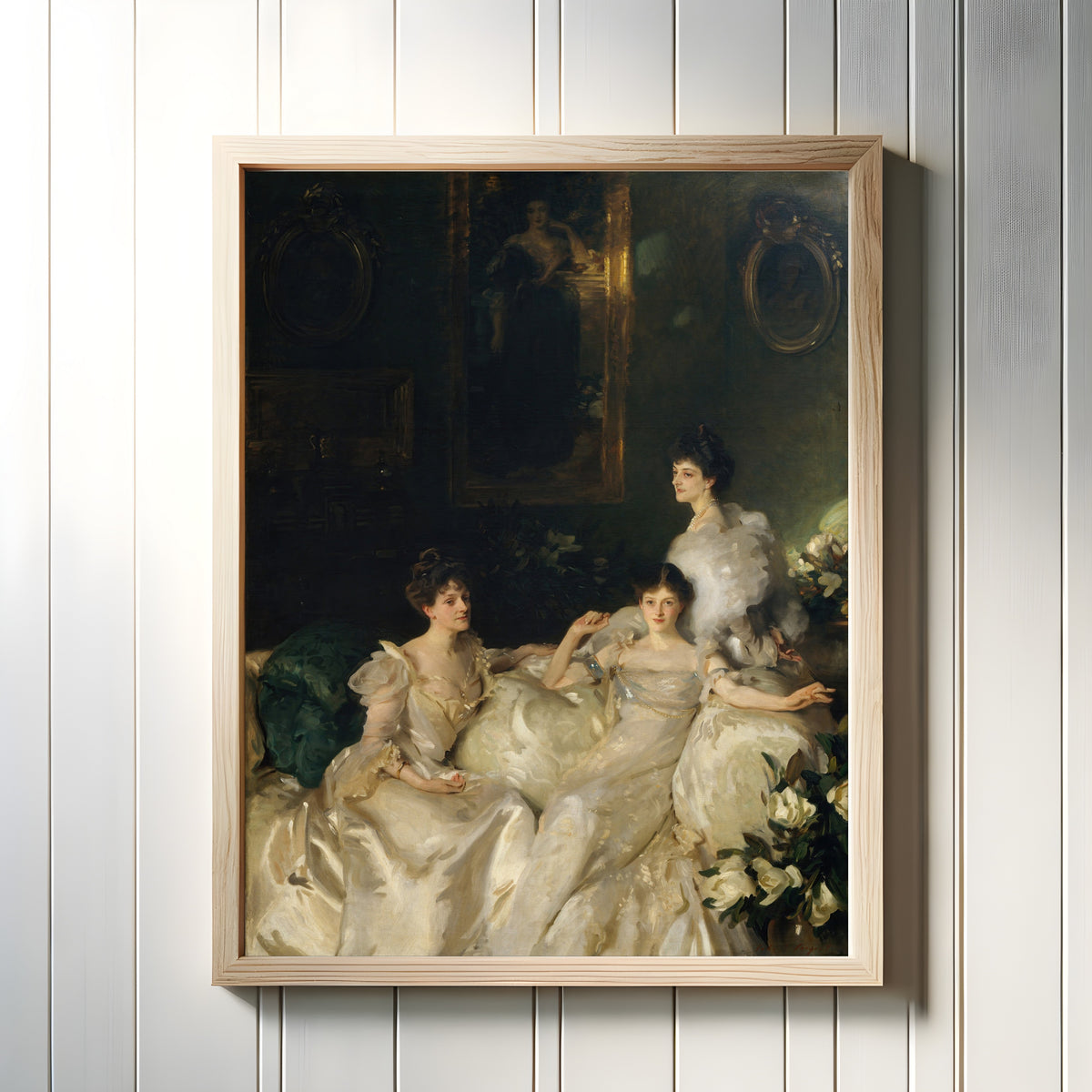 Framed art print of The Wyndham Sisters by John Singer Sargent, in a light wood frame on a white panelled wall