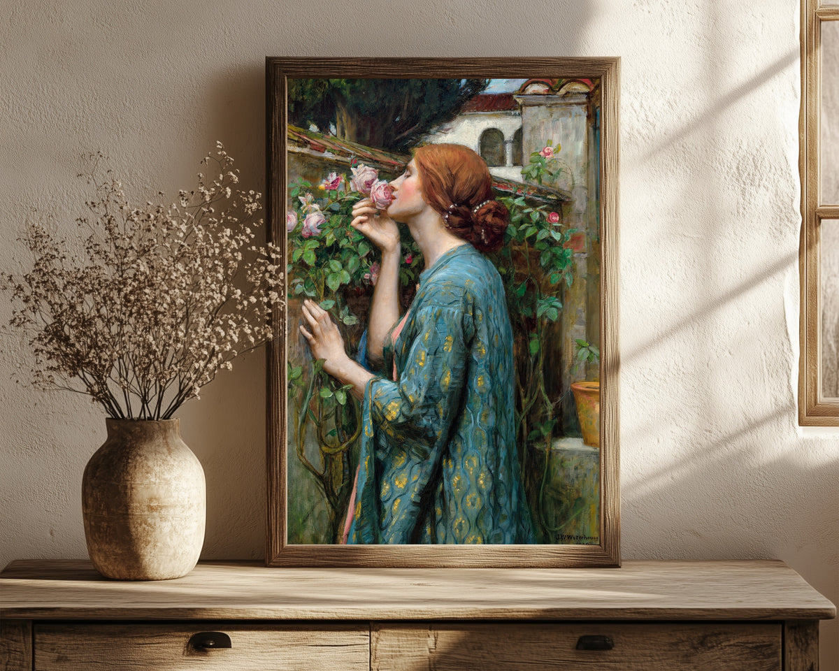 Framed art print of The Soul of the Rose by John William Waterhouse, in a dark wood frame leaning on a rustic console beside dried flowers
