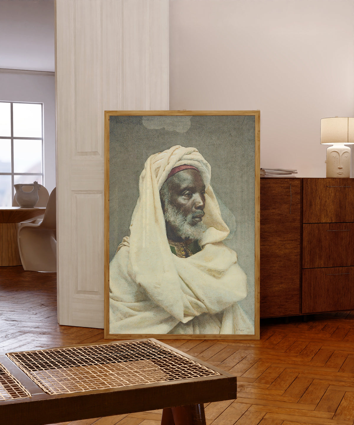 Framed art print of Moorish Elder by Josep Tapiró Baró, in a light wood frame leaning in a warm room with a parquet floor