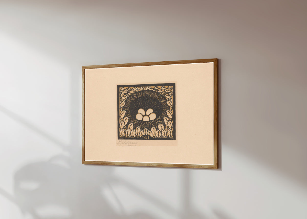 Framed art print of Bird's nest with eggs by Julie de Graag, in a light wood frame on a sunlit white wall, seen at a slight angle
