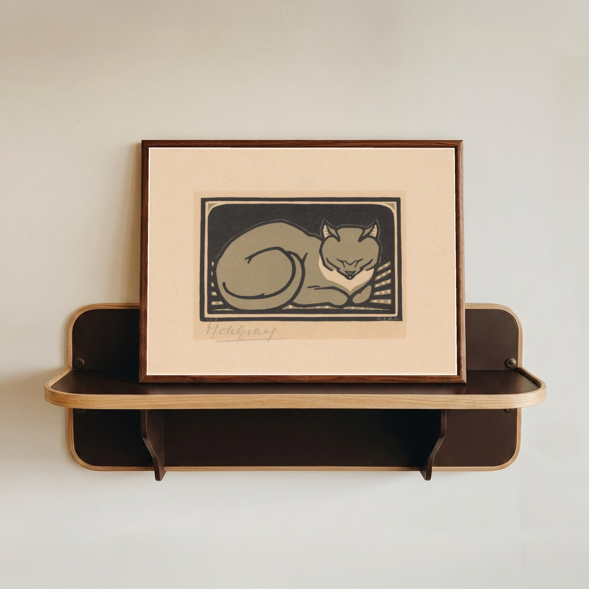 Framed art print of Sleeping Cat by Julie de Graag, in a dark wood frame resting on a wall shelf