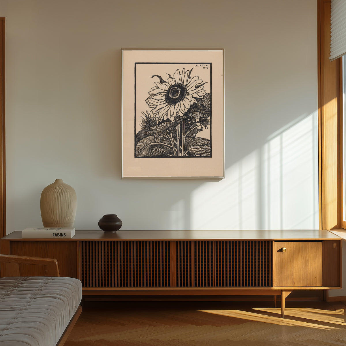 Framed art print of Sunflower by Julie de Graag, in a thin light frame on a sunlit wall above a wooden sideboard