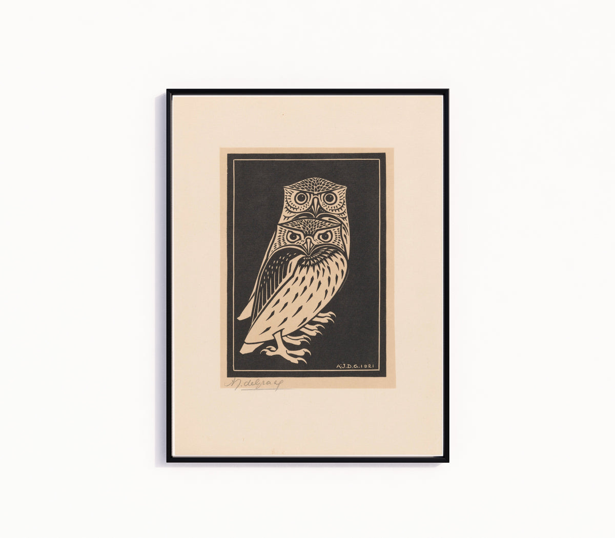 Framed art print of Two Owls by Julie de Graag, in a slim black frame on a plain white wall