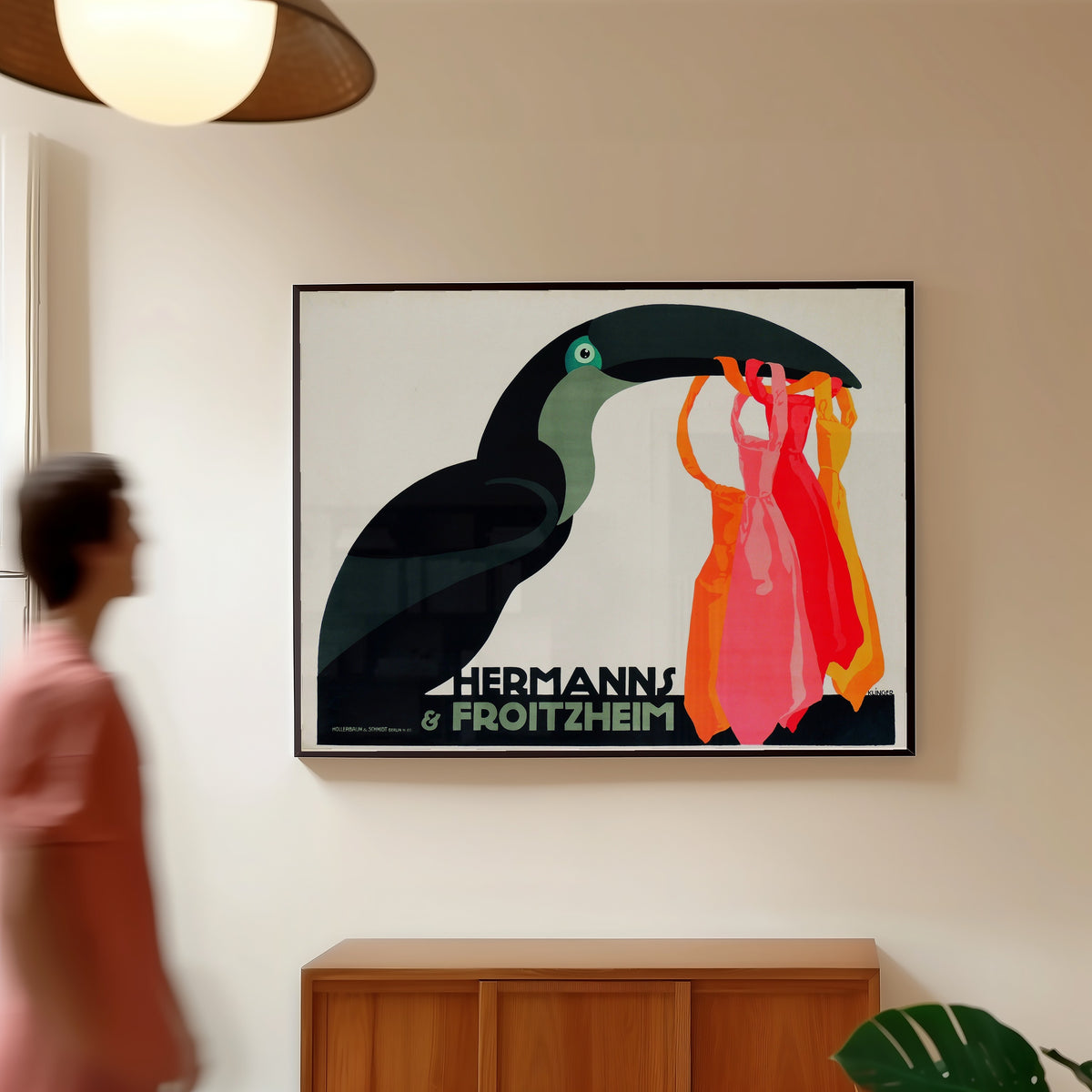 Framed art print of Hermanns & Froitzheim by Julius Klinger, in a slim black frame on a warm wall in a sunlit room