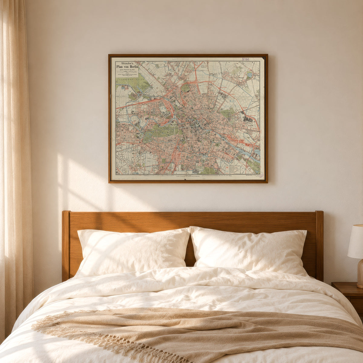 Framed art print of Straube's Plan von Berlin by Julius Straube, in a slim wood frame above a bed in a sunlit bedroom