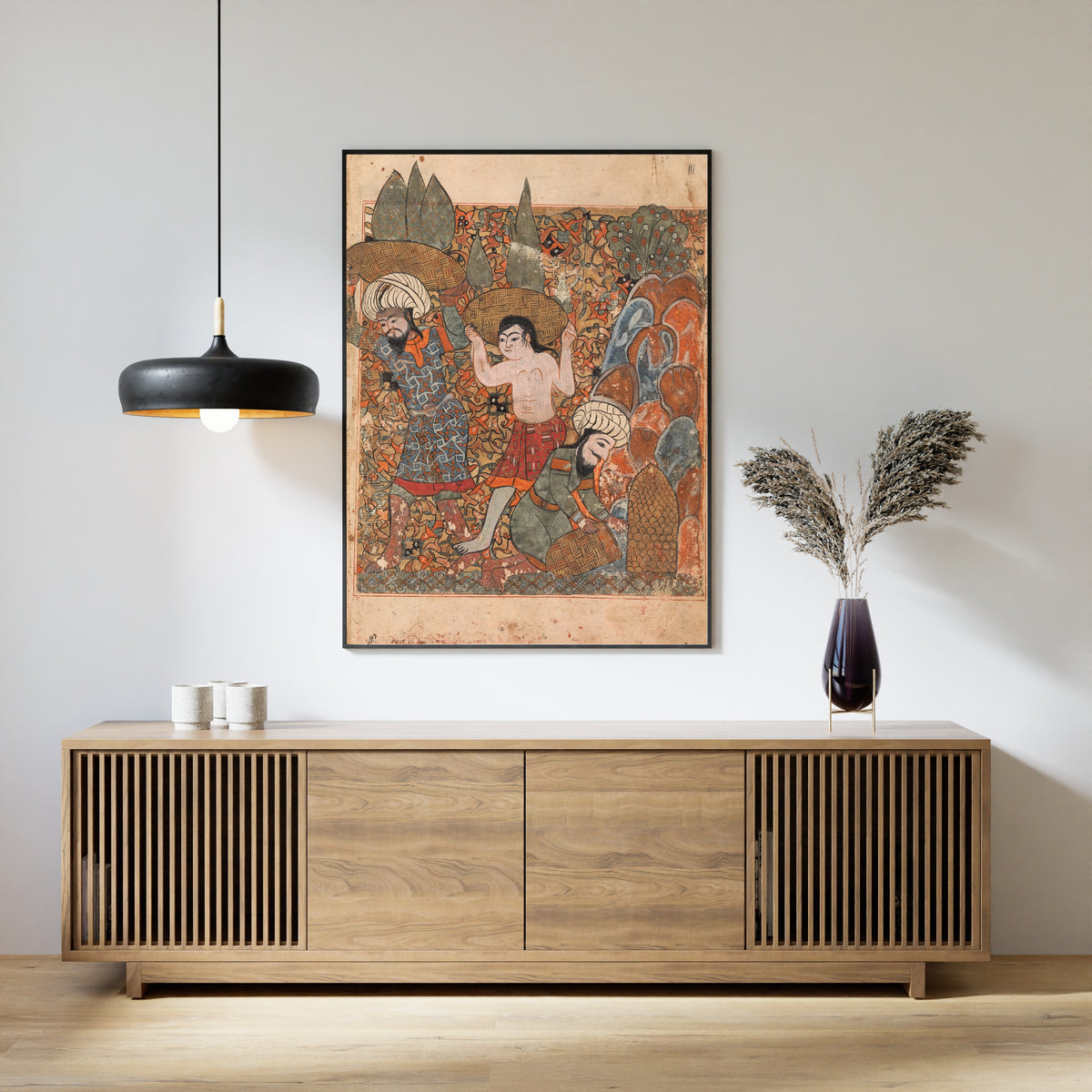 Framed art print of Kalila wa Dimna: The Man who Discovers the Treasure has it Carried Away by Hired Workmen, above a slatted wood sideboard