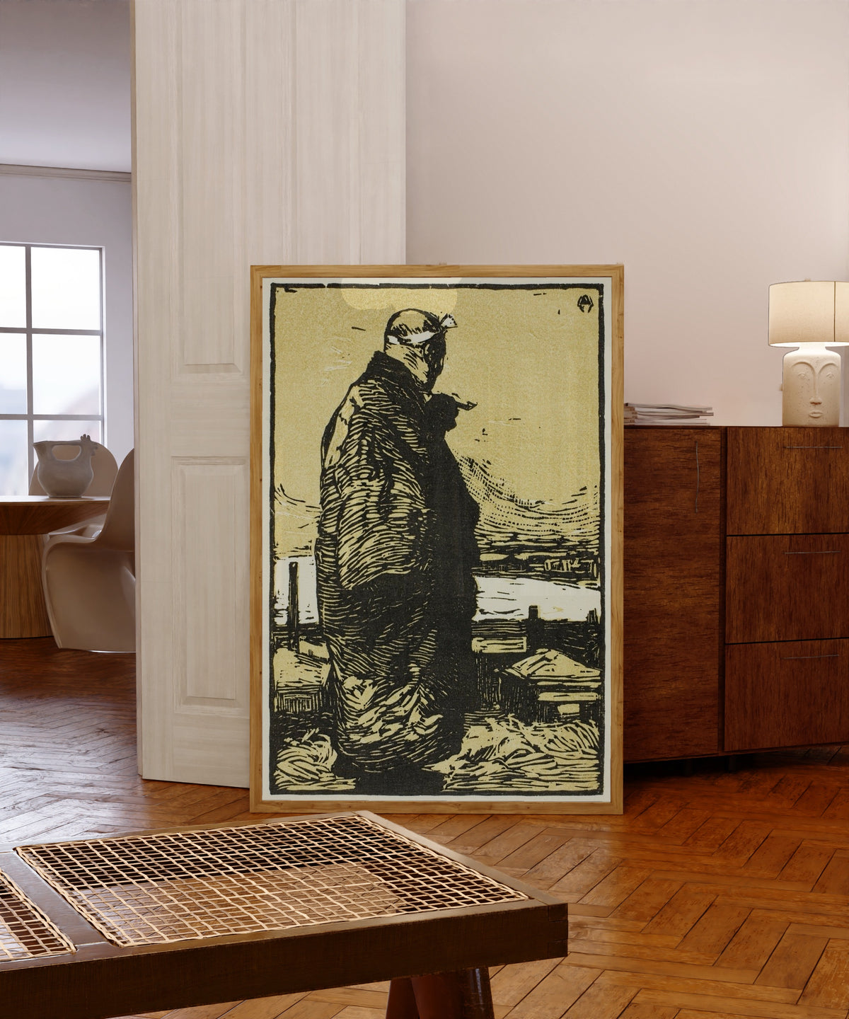 Framed art print of The Fisherman by Kanae Yamamoto, in a light wood frame leaning in a warm room with a parquet floor