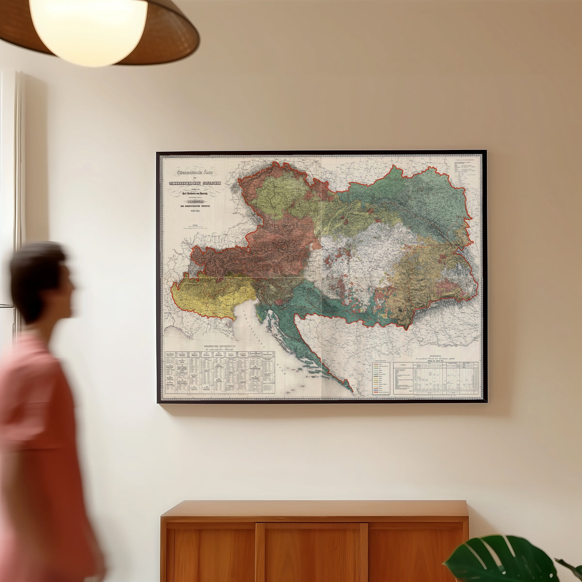 Framed art print of Ethnographic Map of the Austrian Monarchy by Karl von Czoernig, in a slim black frame on a warm wall in a sunlit room