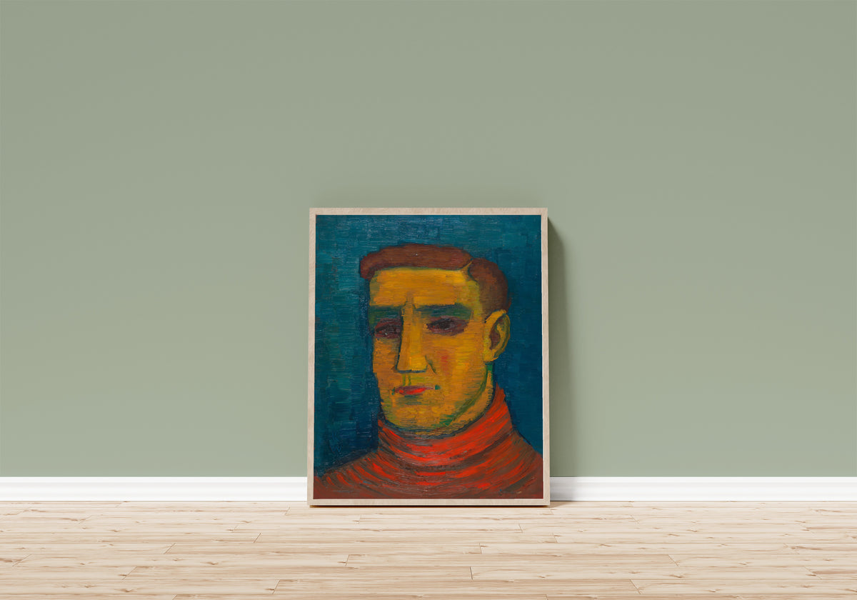 Framed art print of Männliches Porträt (Male Portrait in a Red Sweater) by Karl Wiener, in a light wood frame leaning on a sage green wall above a wooden floor