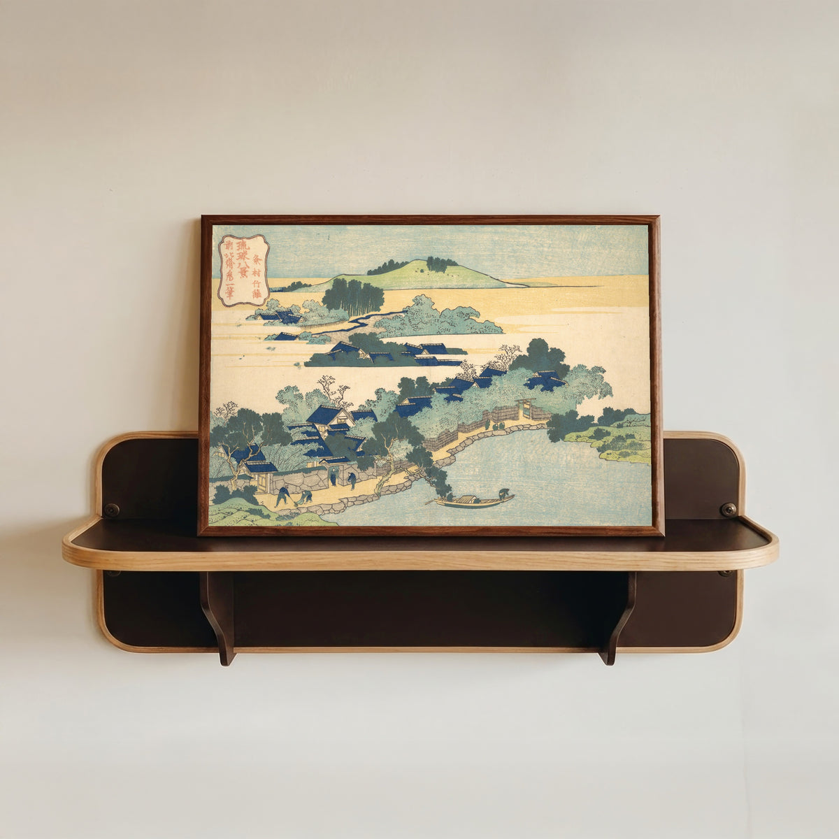 Framed art print of Eight Views of the Ryūkyū Islands: Bamboo Hedge at Kumemura by Katsushika Hokusai, in a dark wood frame resting on a wall shelf
