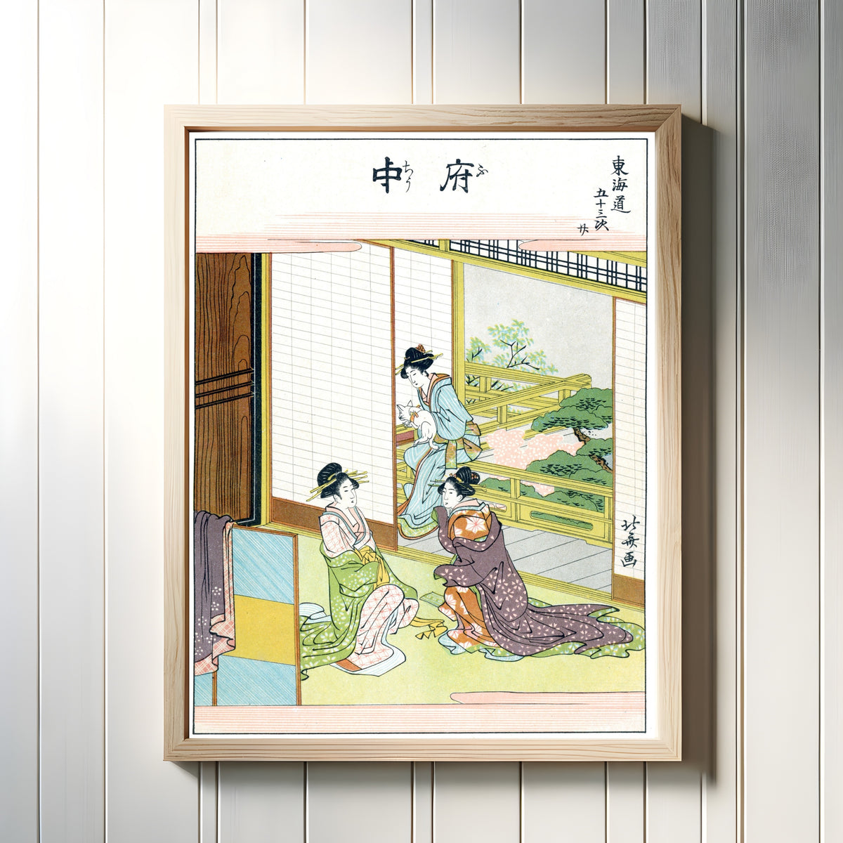 Framed art print of Fifty-three Stations of the Tokaido: Fuchu by Katsushika Hokusai, in a light wood frame on a white panelled wall