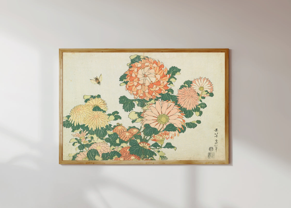 Framed art print of Large Flowers: Chrysanthemums and Horsefly by Katsushika Hokusai, in a light wood frame on a sunlit white wall