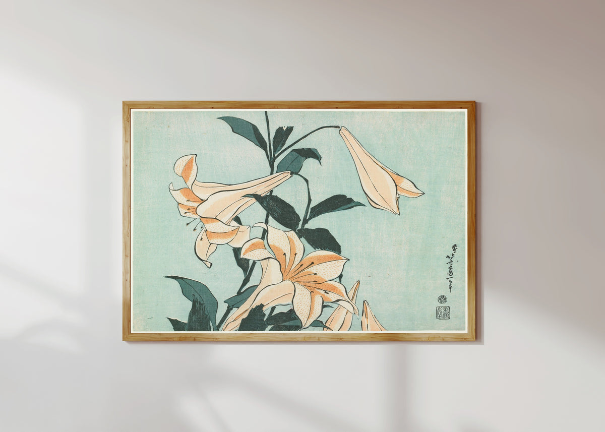 Framed art print of Large Flowers: Lilies by Katsushika Hokusai, in a light wood frame on a sunlit white wall