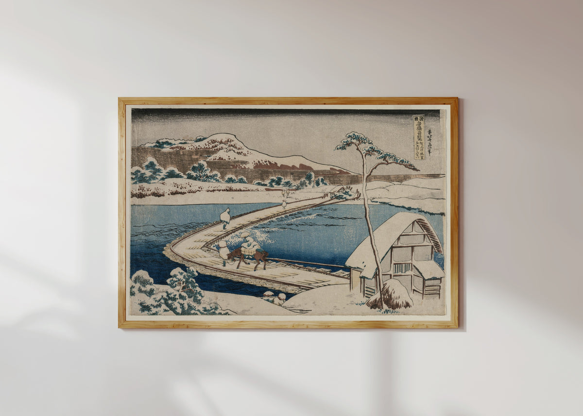 Framed art print of Remarkable Views of Bridges in Various Provinces: An Ancient Picture… by Katsushika Hokusai, in a light wood frame on a sunlit white wall