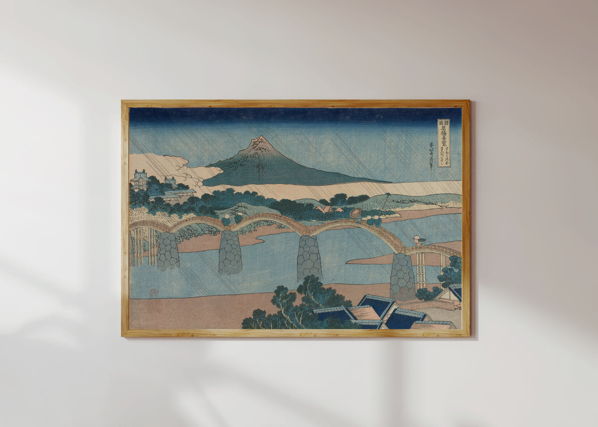 Framed art print of Remarkable Views of Bridges in Various Provinces: The Brocade Bridge… by Katsushika Hokusai, in a light wood frame on a sunlit white wall
