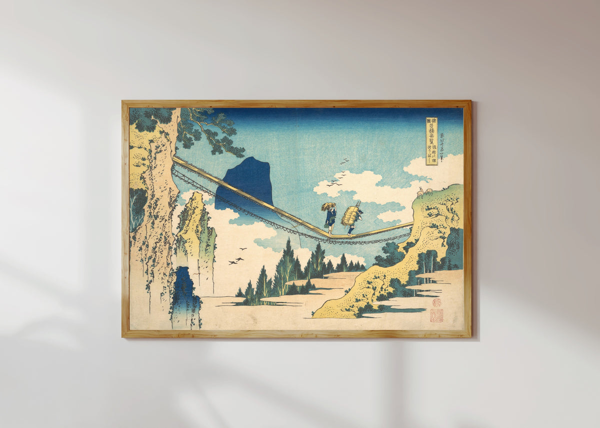 Framed art print of Remarkable Views of Bridges in Various Provinces: The Suspension… by Katsushika Hokusai, in a light wood frame on a sunlit white wall