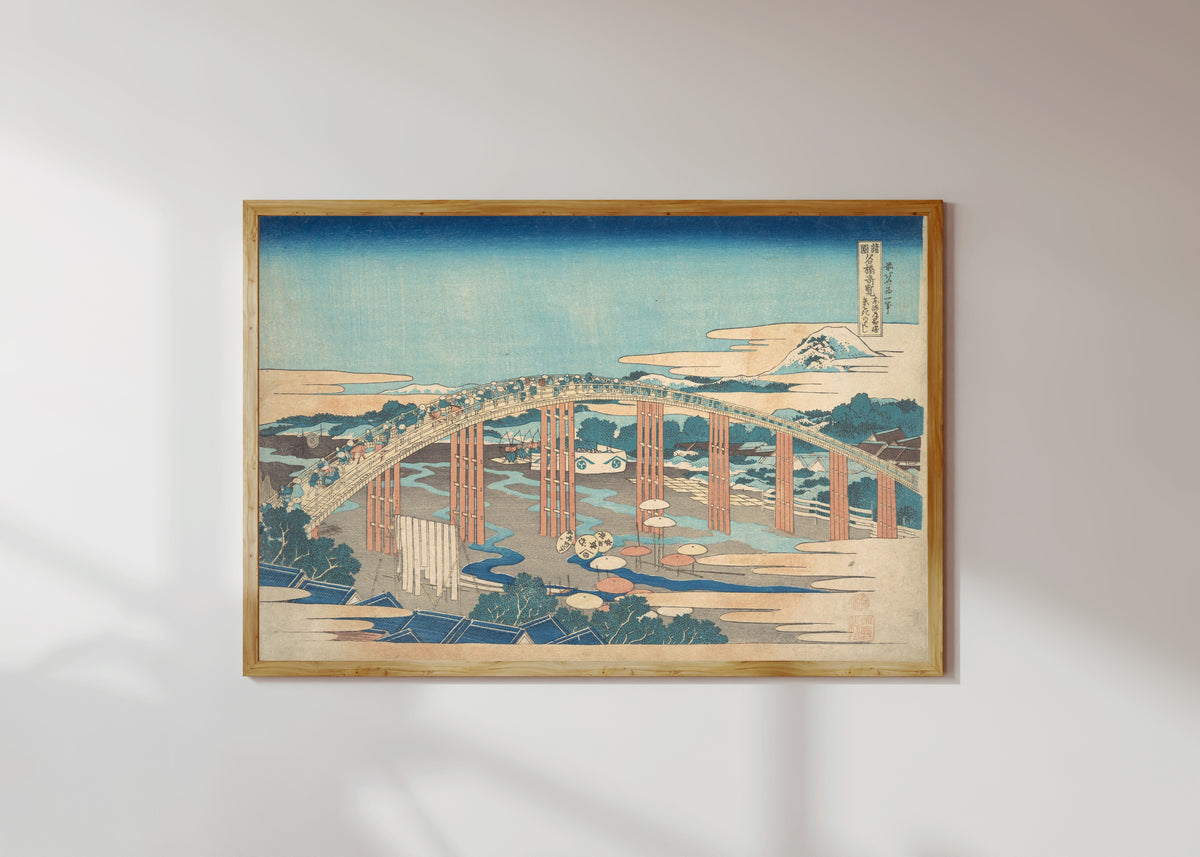 Framed art print of Remarkable Views of Bridges in Various Provinces: Yahagi Bridge at… by Katsushika Hokusai, in a light wood frame on a sunlit white wall