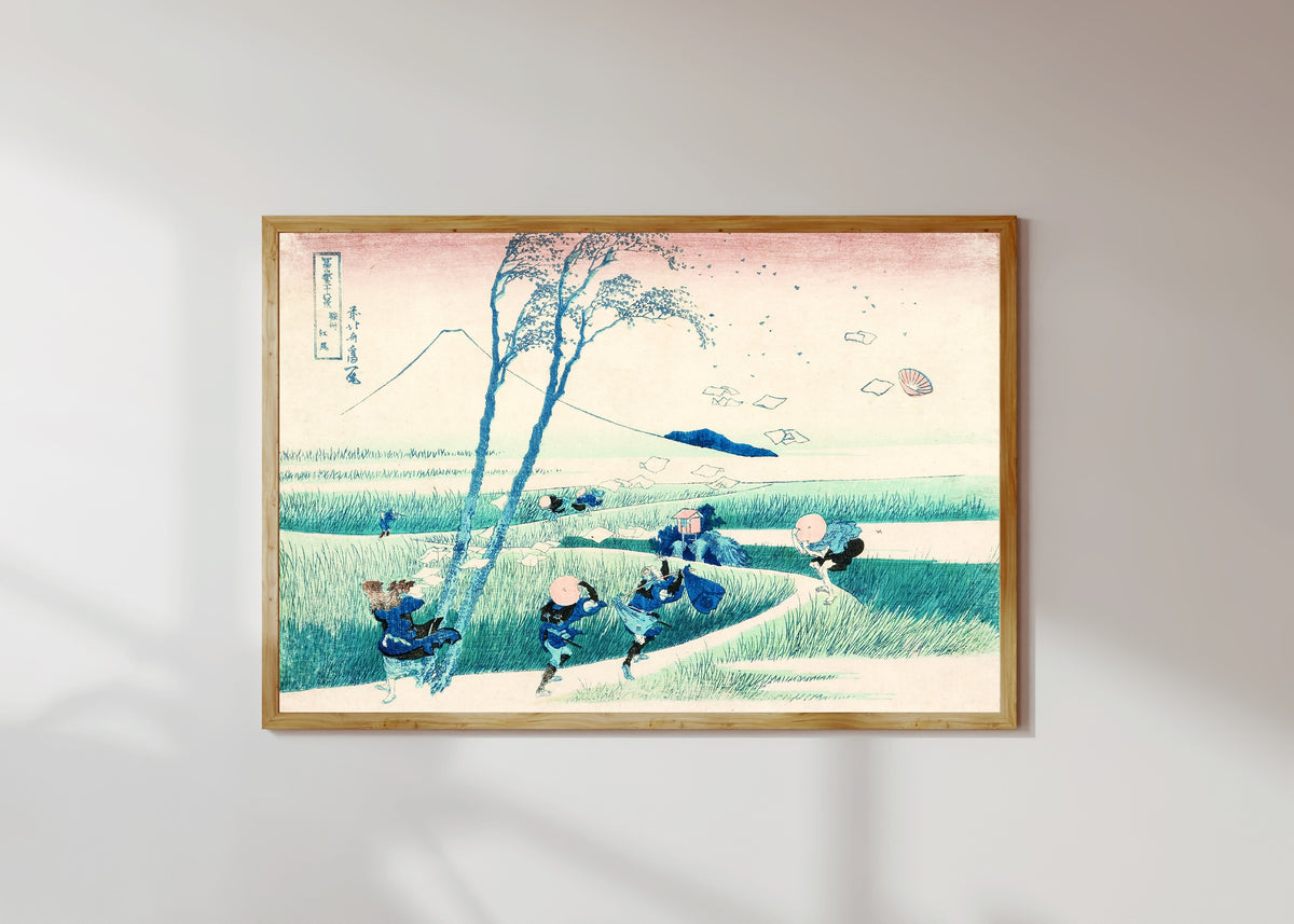 Framed art print of Thirty-six Views of Mount Fuji: Ejiri in Suruga Province by Katsushika Hokusai, in a light wood frame on a sunlit white wall