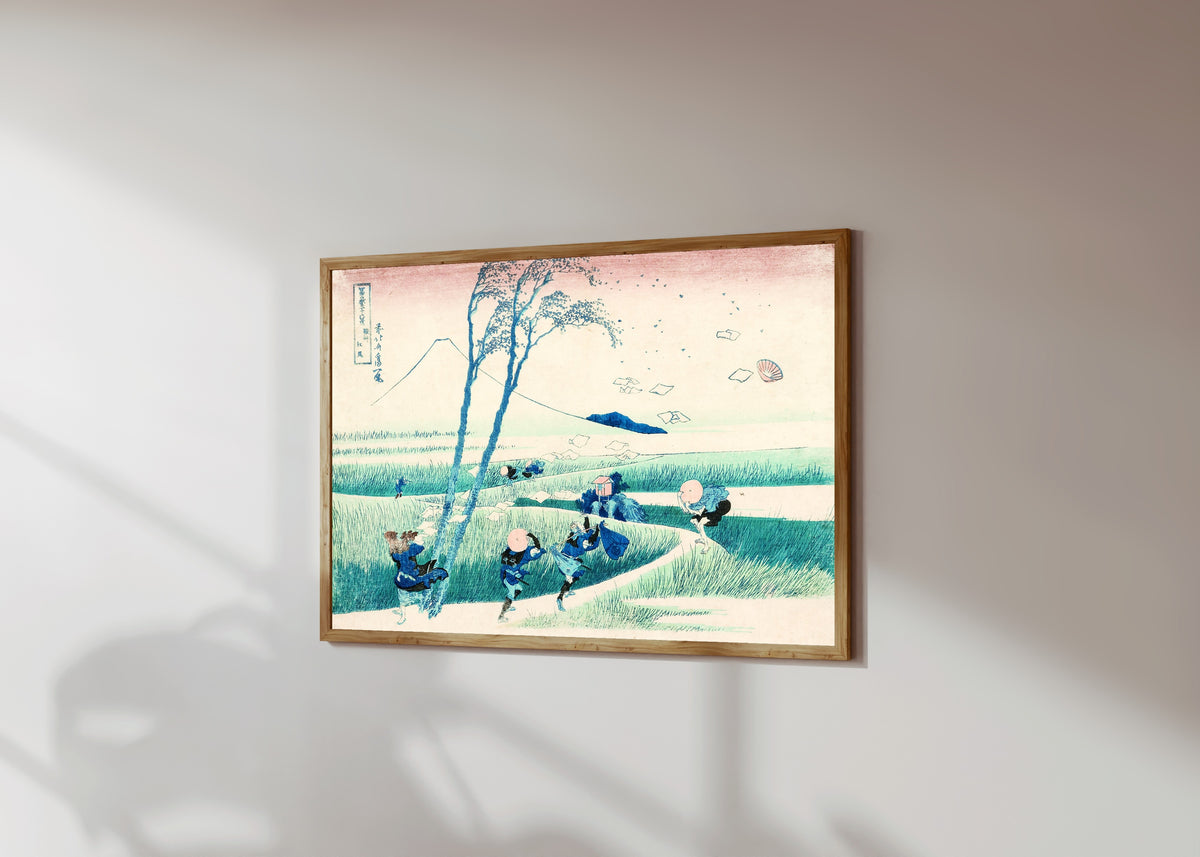 Framed art print of Thirty-six Views of Mount Fuji: Ejiri in… by Katsushika Hokusai, in a light wood frame on a sunlit white wall, seen at a slight angle