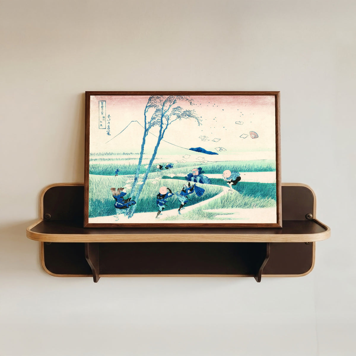 Framed art print of Thirty-six Views of Mount Fuji: Ejiri in Suruga Province by Katsushika Hokusai, in a dark wood frame resting on a wall shelf