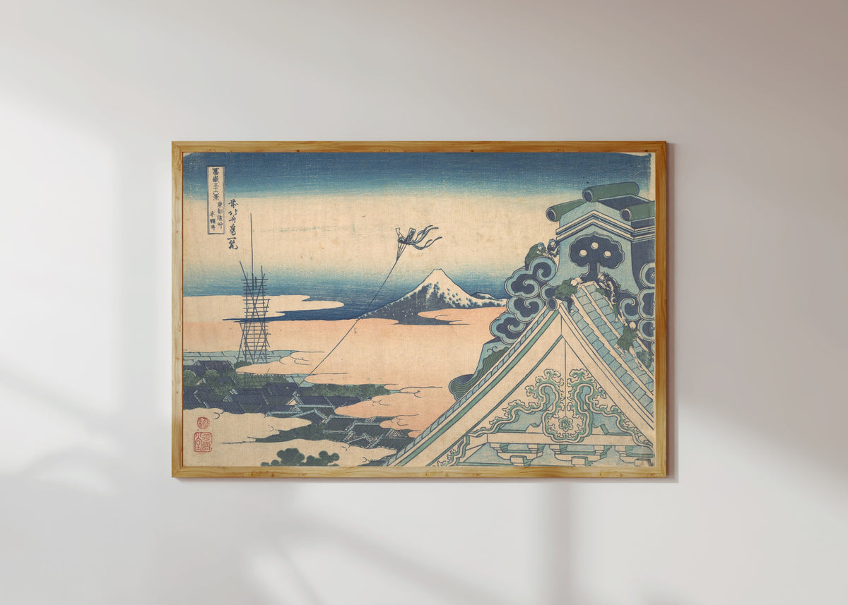 Framed art print of Thirty-six Views of Mount Fuji: Honganji at Asakusa in Edo by Katsushika Hokusai, in a light wood frame on a sunlit white wall