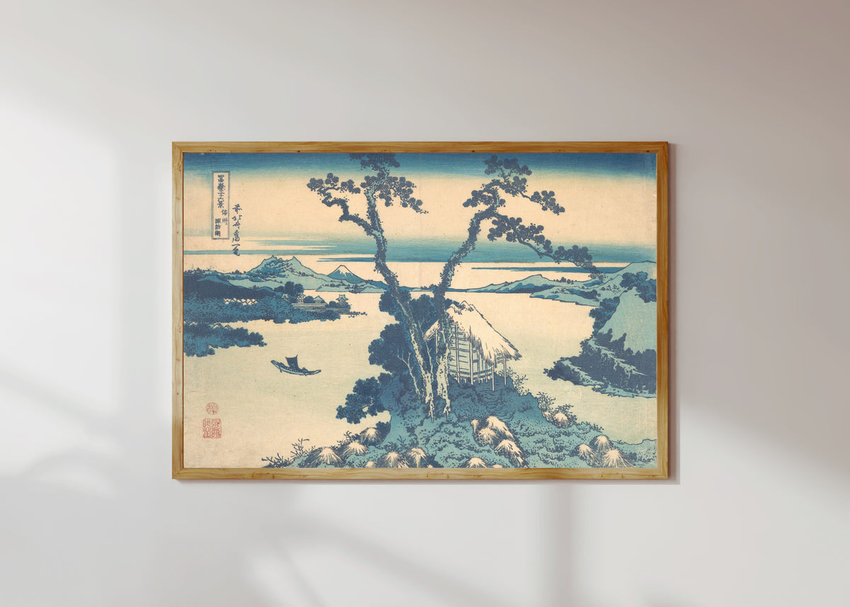 Framed art print of Thirty-six Views of Mount Fuji: Lake Suwa in Shinano Province by Katsushika Hokusai, in a light wood frame on a sunlit white wall