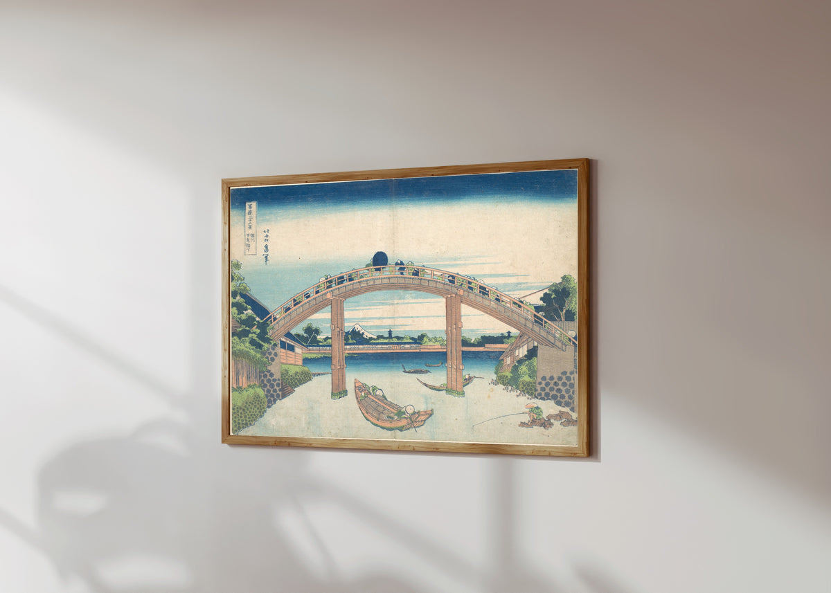 Framed art print of Thirty-six Views of Mount Fuji: Under the… by Katsushika Hokusai, in a light wood frame on a sunlit white wall, seen at a slight angle