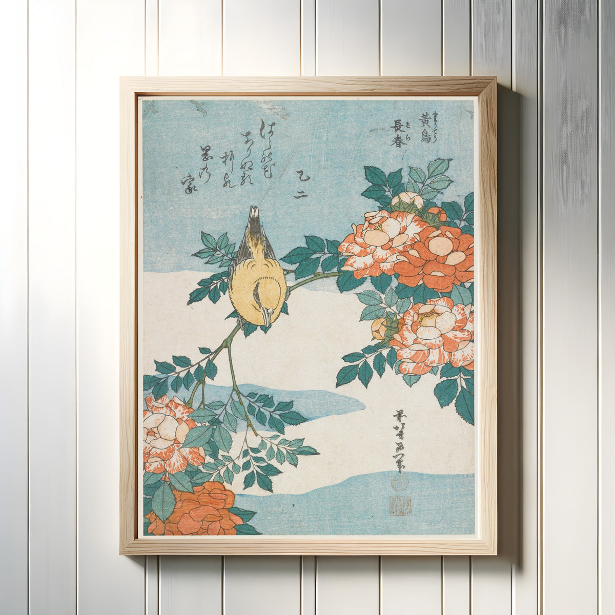 Framed art print of Warbler and Roses by Katsushika Hokusai, in a light wood frame on a white panelled wall