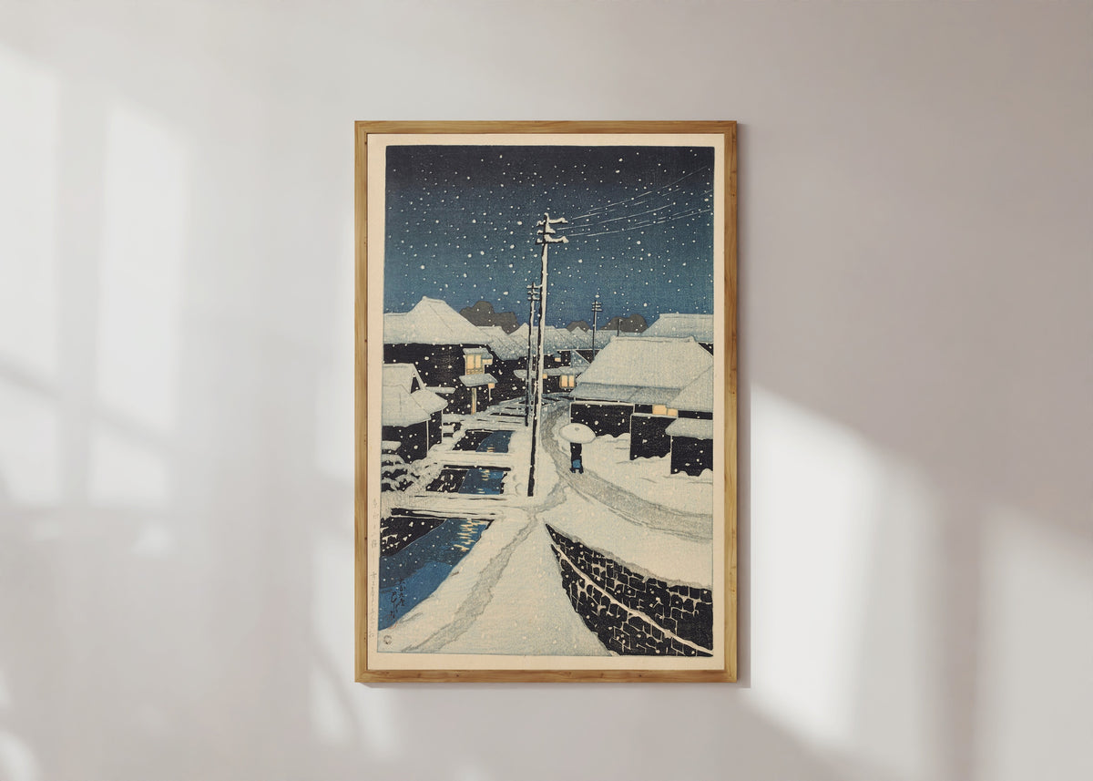 Framed art print of Evening Snow at Terajima Village by Kawase Hasui, in a light wood frame on a sunlit white wall