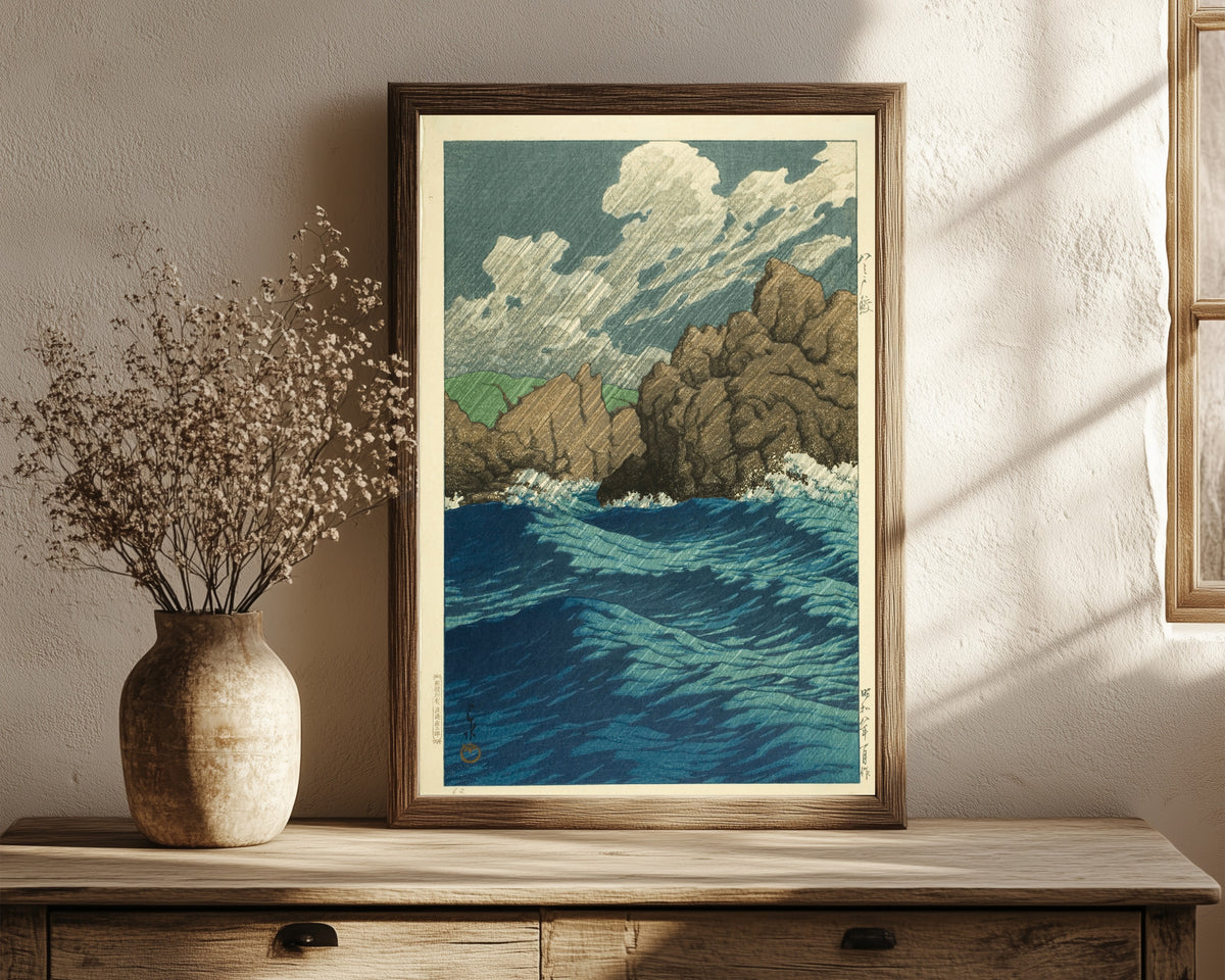 Framed art print of Hachinohe Same by Kawase Hasui, in a dark wood frame leaning on a rustic console beside dried flowers