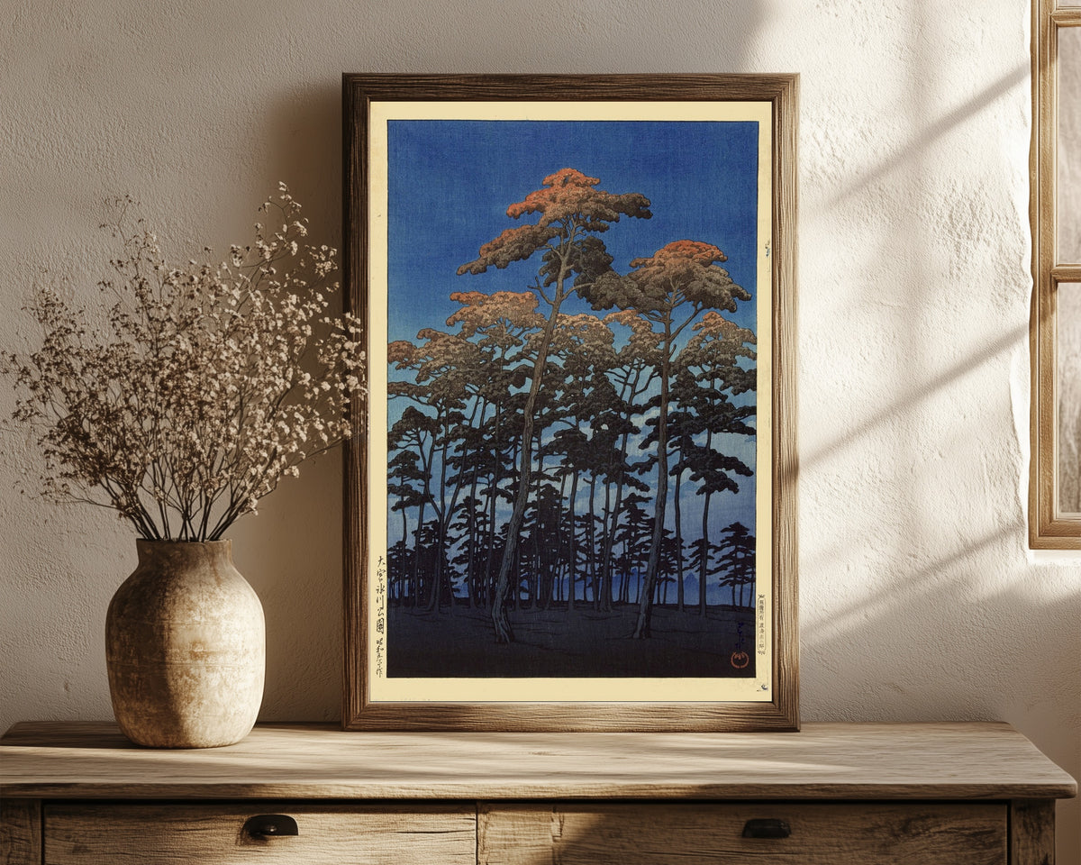Framed art print of Hikawa Park, Omiya by Kawase Hasui, in a dark wood frame leaning on a rustic console beside dried flowers