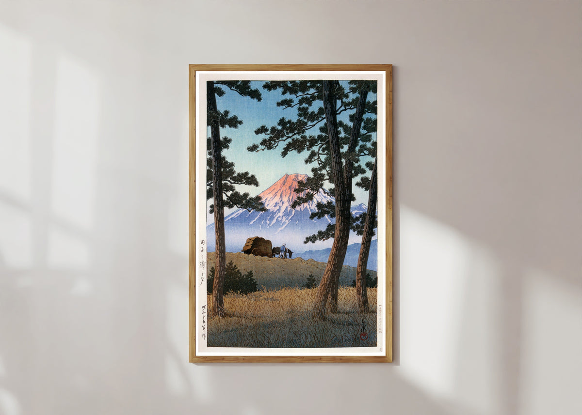 Framed art print of Fuji Mountain by Kawase Hasui, in a light wood frame on a sunlit white wall