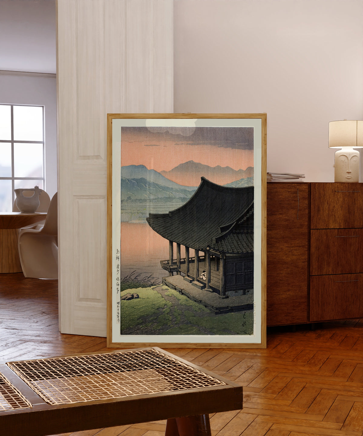 Framed art print of Imhae Pavillion by Kawase Hasui, in a light wood frame leaning in a warm room with a parquet floor