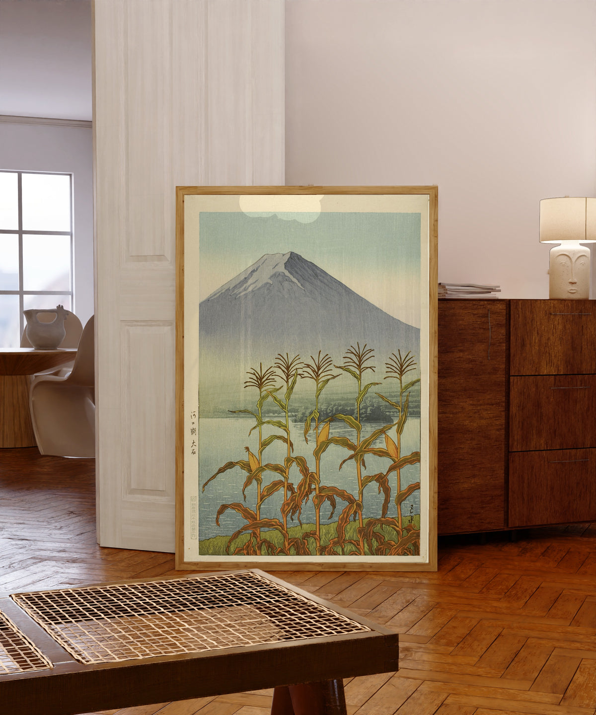 Framed art print of Lake Kawaguchi, Oishi by Kawase Hasui, in a light wood frame leaning in a warm room with a parquet floor