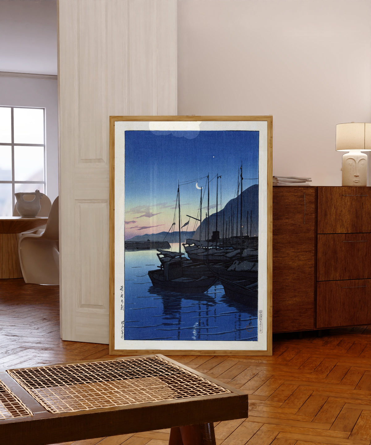 Framed art print of Morning in Beppu by Kawase Hasui, in a light wood frame leaning in a warm room with a parquet floor