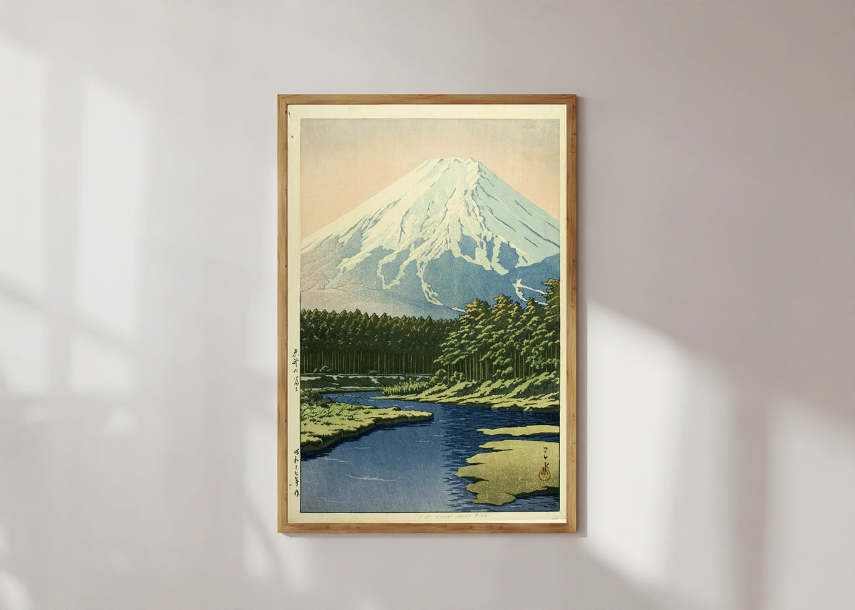 Framed art print of Mount Fuji from Oshino by Kawase Hasui, in a light wood frame on a sunlit white wall