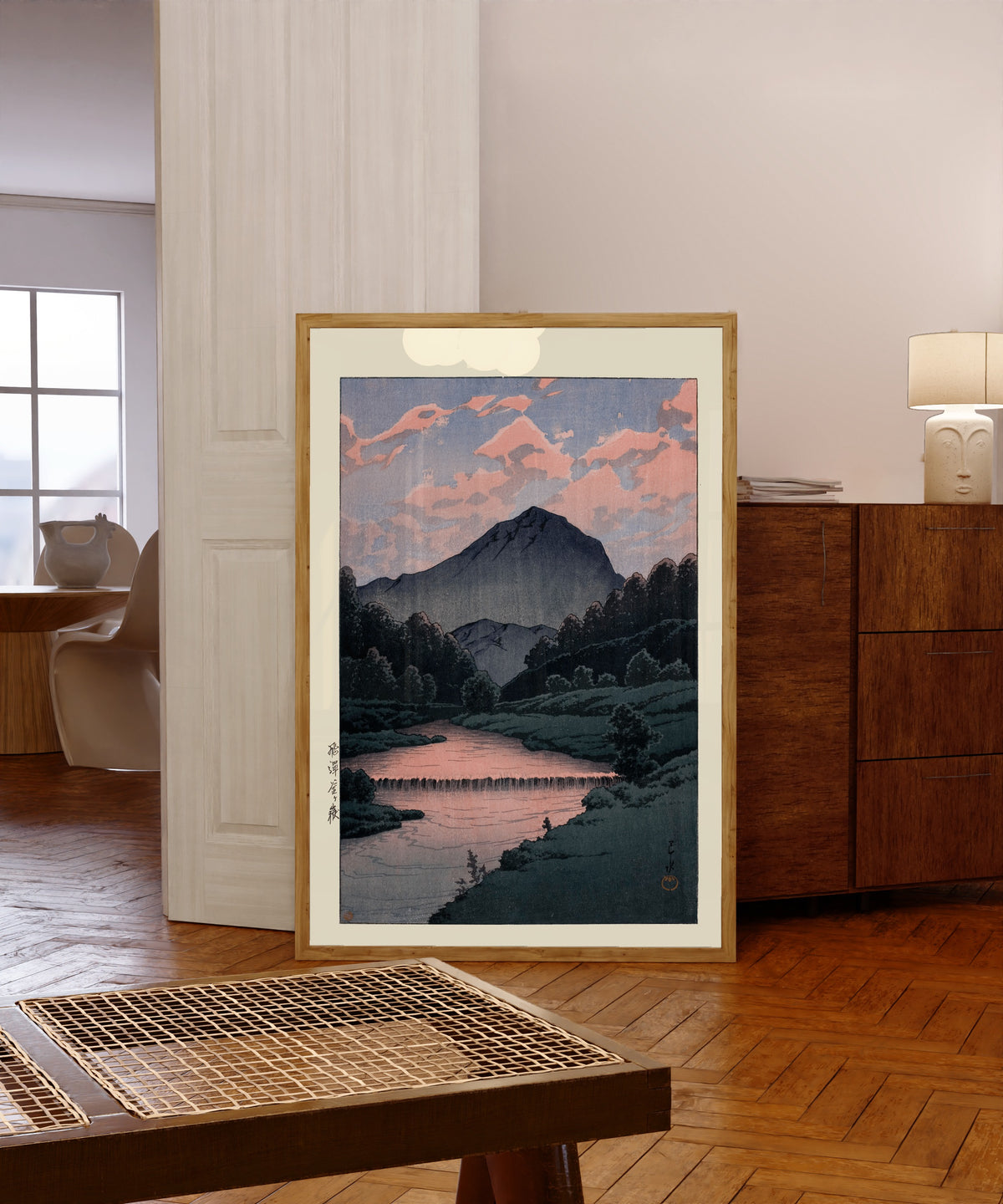 Framed art print of Mount Kamagatake, Hida by Kawase Hasui, in a light wood frame leaning in a warm room with a parquet floor