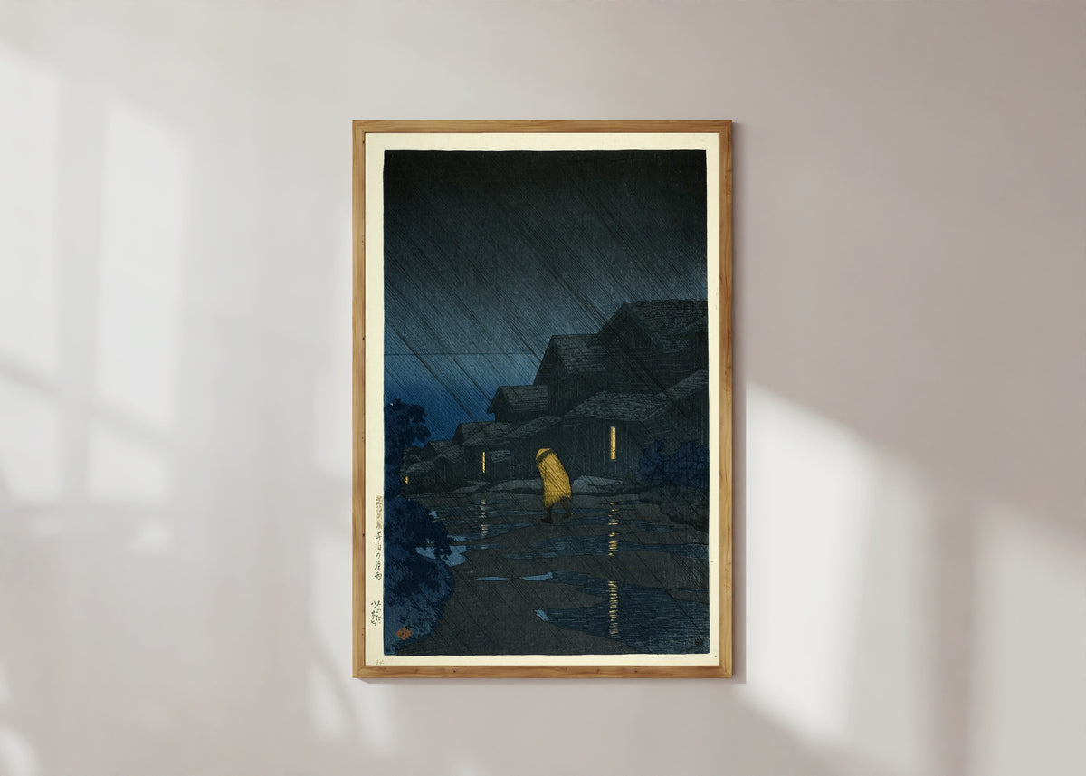 Framed art print of Rain at Teradomari Giclée Print: by Kawase Hasui, in a light wood frame on a sunlit white wall