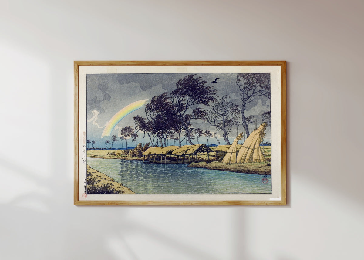Framed art print of Rainbow at Hatta, Kaga Province by Kawase Hasui, in a light wood frame on a sunlit white wall