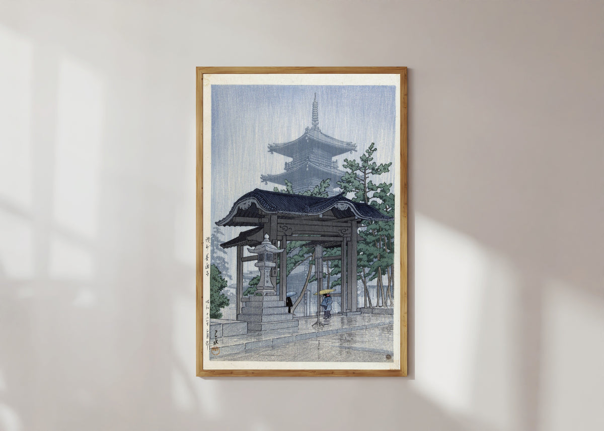 Framed art print of Zentsuji Temple, Sanuki, in Rain by Kawase Hasui, in a light wood frame on a sunlit white wall