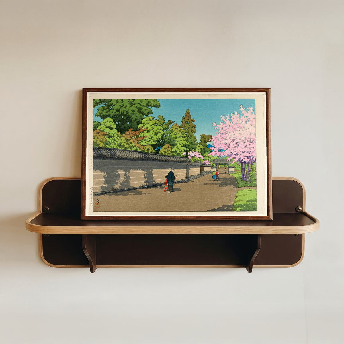 Framed art print of Spring at Daigo, Kyoto by Kawase Hasui, in a dark wood frame resting on a wall shelf