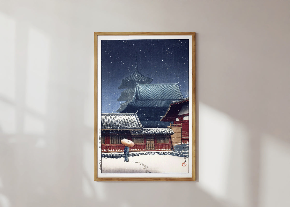 Framed art print of Tennoji Temple, Osaka, in Snow by Kawase Hasui, in a light wood frame on a sunlit white wall