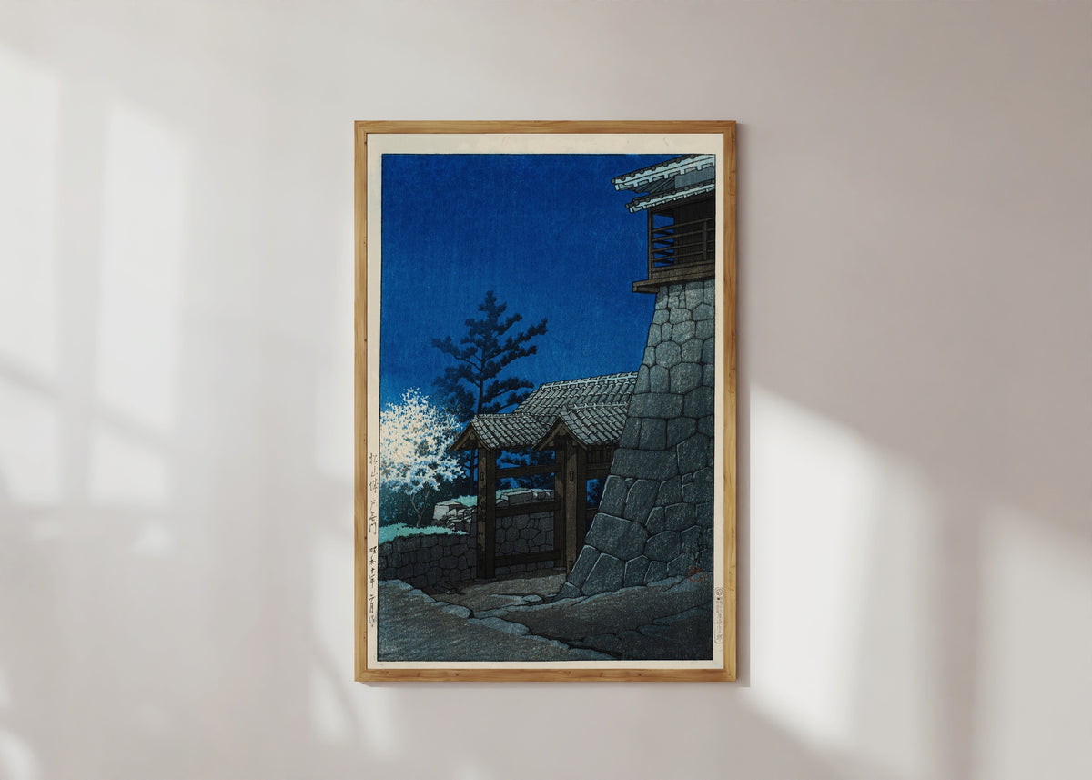 Framed art print of Tonashi Gate, Matsuyama Castle by Kawase Hasui, in a light wood frame on a sunlit white wall