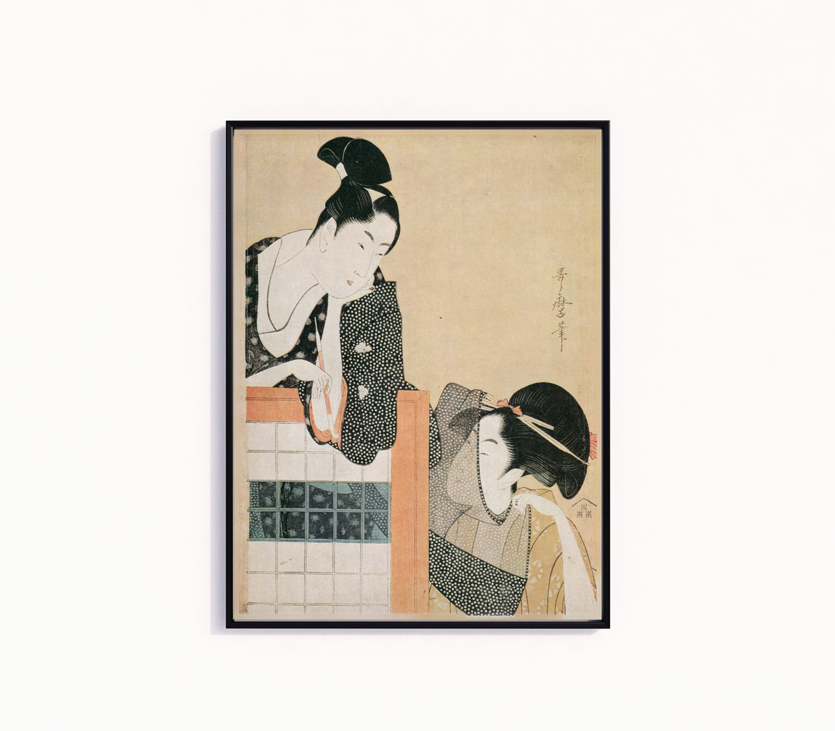 Framed art print of Lovers Behind a Screen by Kitagawa Utamaro, in a slim black frame on a plain white wall