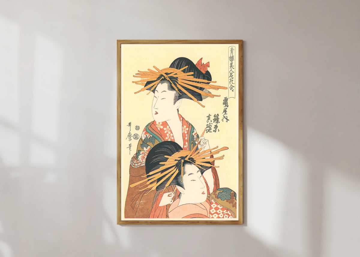 Framed art print of Shinohara and Masagi of the Tsuruya by Kitagawa Utamaro, in a light wood frame on a sunlit white wall