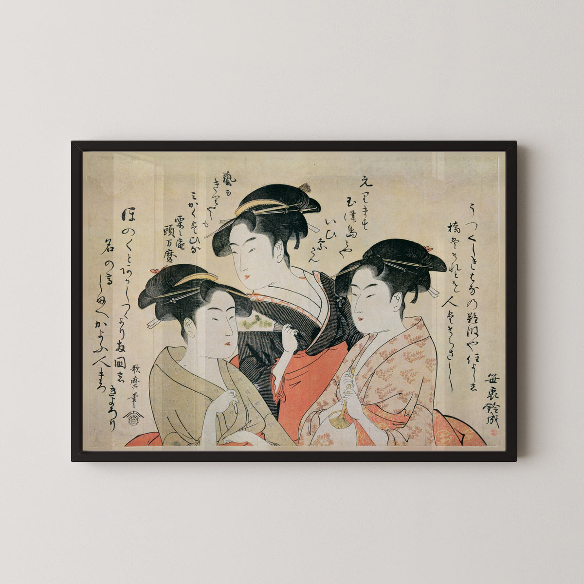 Three Beauties of the Present Day: Okita, Toyohina, Ohisa by Kitagawa Utamaro — in a black frame on a pale wall