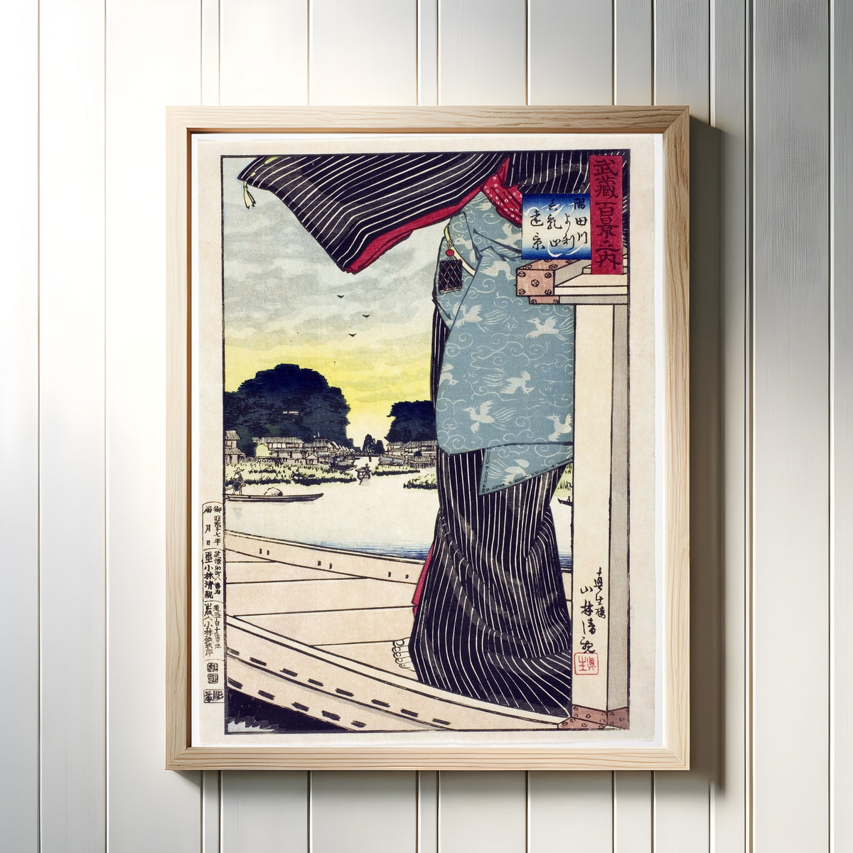 Framed art print of Sumida River by Kobayashi Kiyochika, in a light wood frame on a white panelled wall