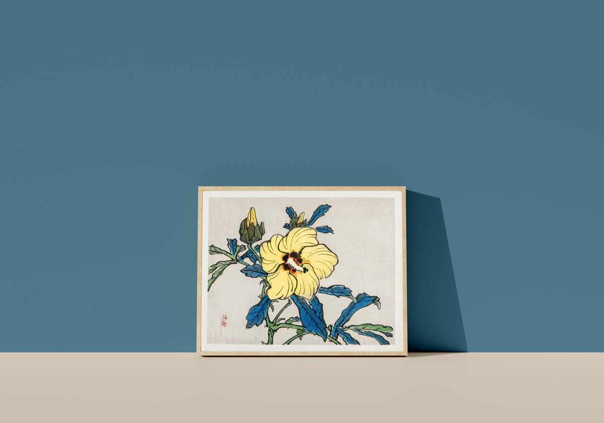 Framed art print of Hibiscus by Kono Bairei, in a light wood frame leaning on a blue wall