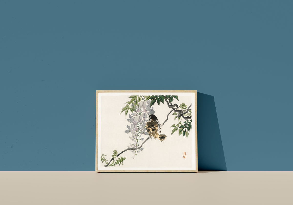 Framed art print of Sparrow on a branch by Kōno Bairei, in a light wood frame leaning on a blue wall