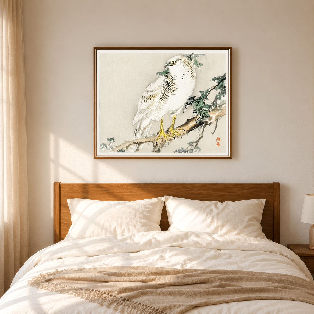 Framed art print of White Hawk on an Evergreen Branch by Kōno Bairei, in a slim wood frame above a bed in a sunlit bedroom